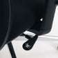 Side view of black mesh office chair showing height adjustment lever