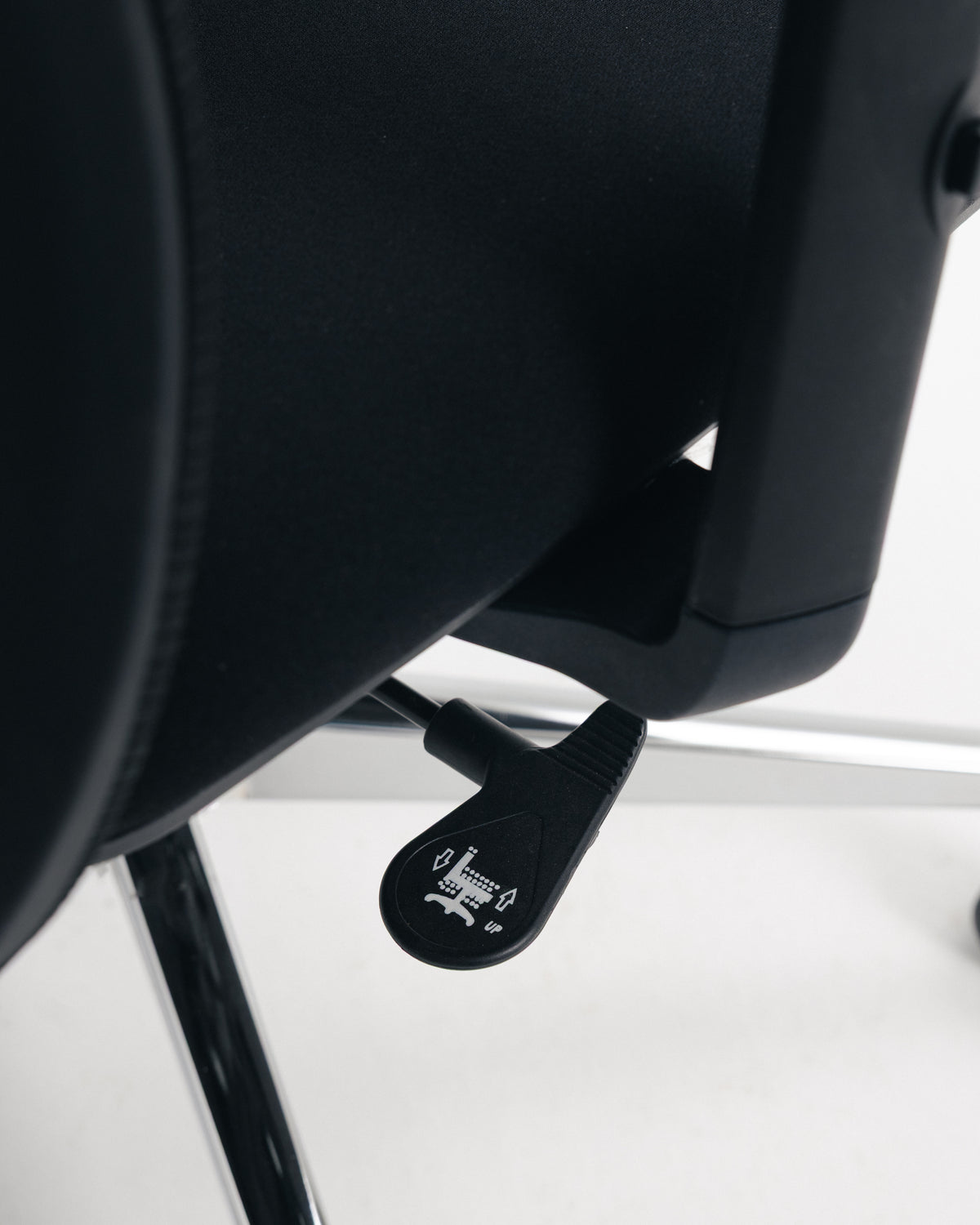 Side view of black mesh office chair showing height adjustment lever