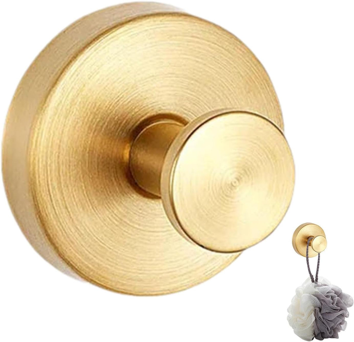 A round, brushed gold wall hook is mounted on a smooth surface, featuring a simple, modern design. A small white and gray scrunchie hangs from the hook, adding a touch of elegance to the overall aesthetic.